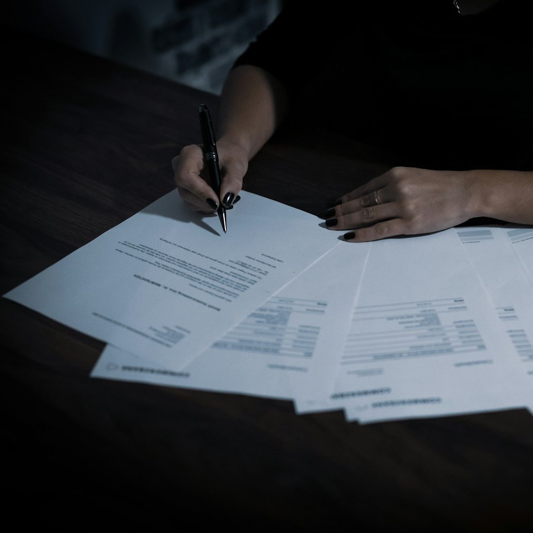 Vor der Auswanderung regeln – wichtige To-dos für Familien Hand schreibt auf Zettel – To-do-Liste für Familien vor der Auswanderung